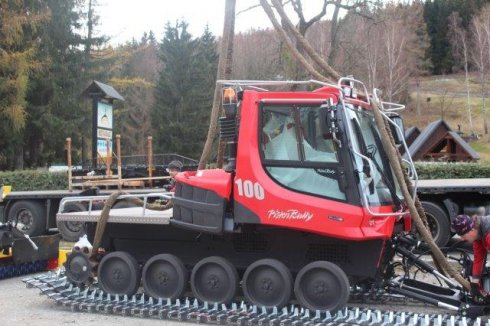 Usazování stroje PistenBully 100 do pásů