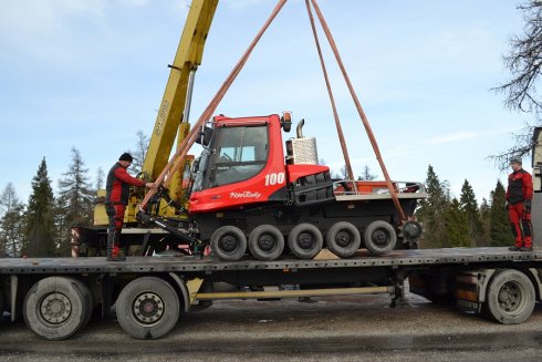 Rolba opouští přívěs kamionu. Na vykládku dohlíží mechanici Robo a Ivan.