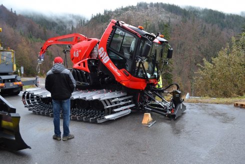 Nasazování levého pásu na PistenBully 600 s navijákem a technologií SNOWsat.