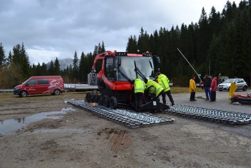 Servisní mechanici TopKarMoto, Róbo a Ondra, upevňují přední nánosník na stroj.